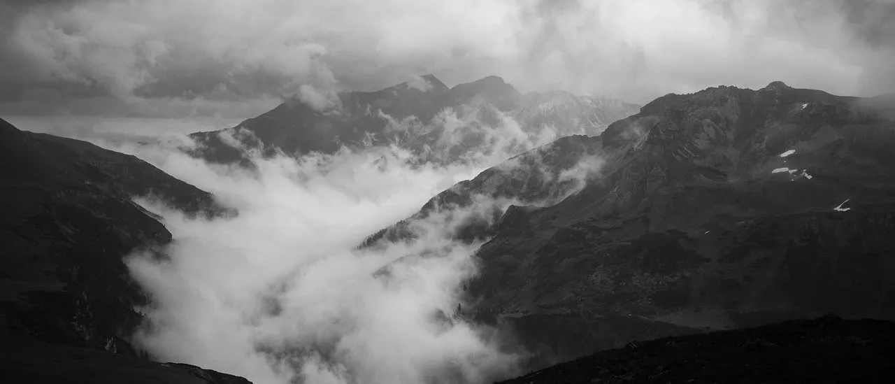 Layered mountain ridges shrouded in dense fog — monochrome fine art landscape