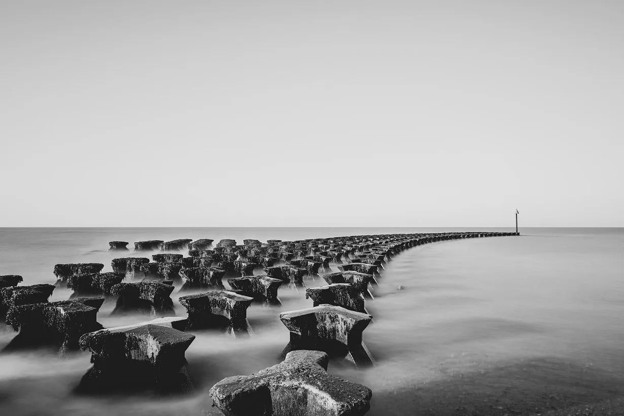 Minimalist long exposure of a jetty stretching to the horizon