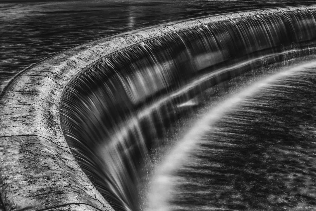 Abstract long exposure of a concrete edge with rushing water